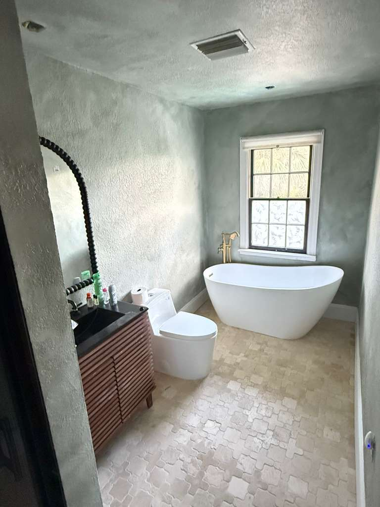 Bathroom with arabesque patterned tile floor and freestanding tub — luxury tile installation in Bradenton home