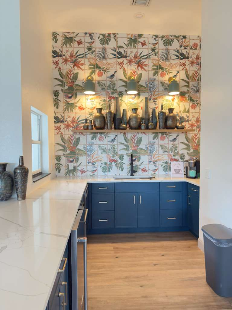 Kitchen wet bar with dramatic botanical print tile backsplash and navy blue cabinets in Lakewood Ranch home