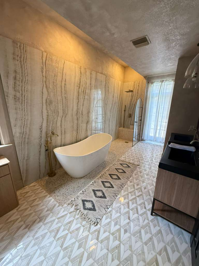 Luxury master bath renovation with freestanding tub and custom patterned tile floor in Sarasota home