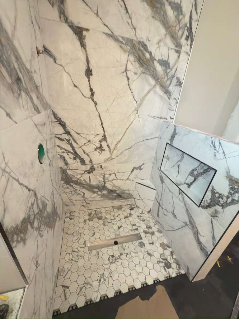 Large format marble-look porcelain tile shower walls with hexagon mosaic floor — Sarasota large format tile installation